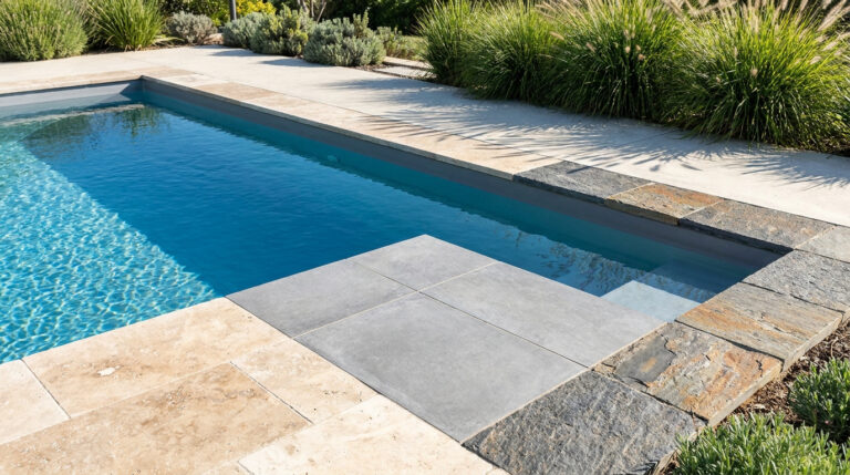 Piscine moderne avec des margelles en pierre naturelle et carrelage gris contrastant.